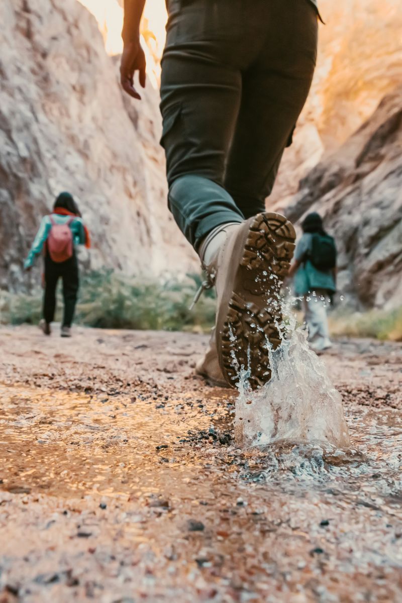 The Lodges of Huntersville A person walking through a flowing stream of water, with splashes around their feet.