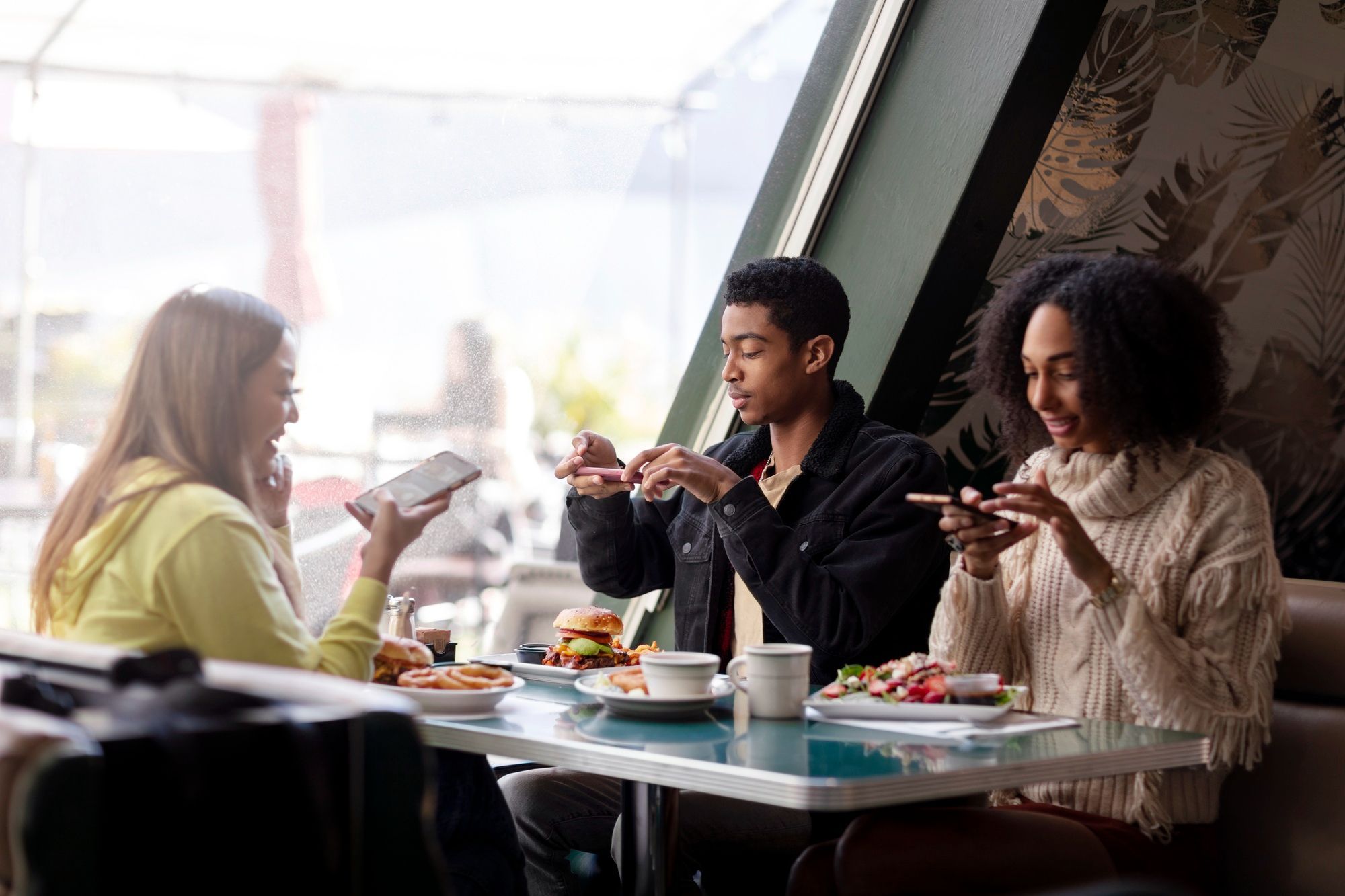 The Lodges of Huntersville Three people seated at a table enjoying a meal with various food items and drinks in front of them.