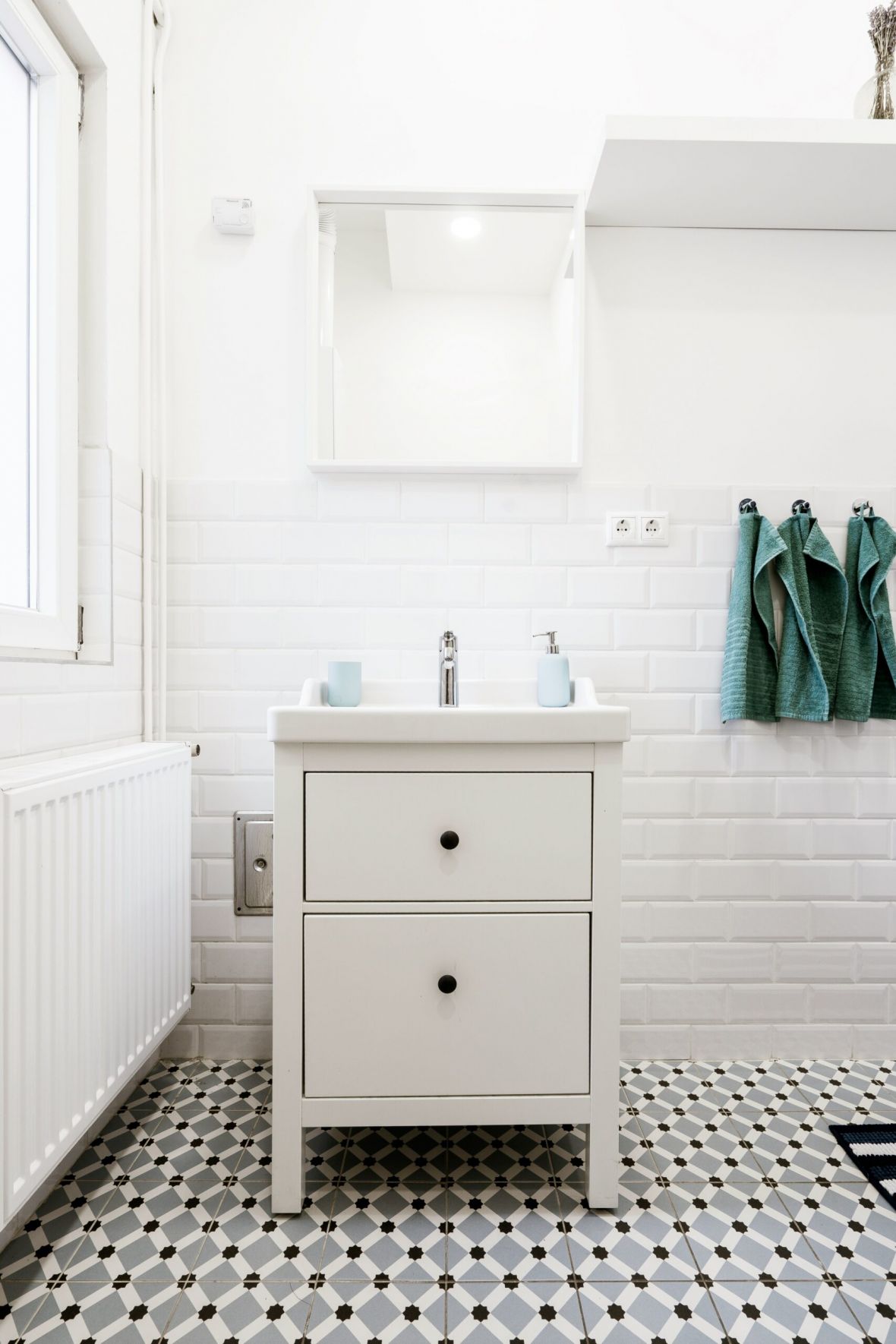 The Lodges of Huntersville A bathroom featuring a white sink and a stylish black and white tiled floor.