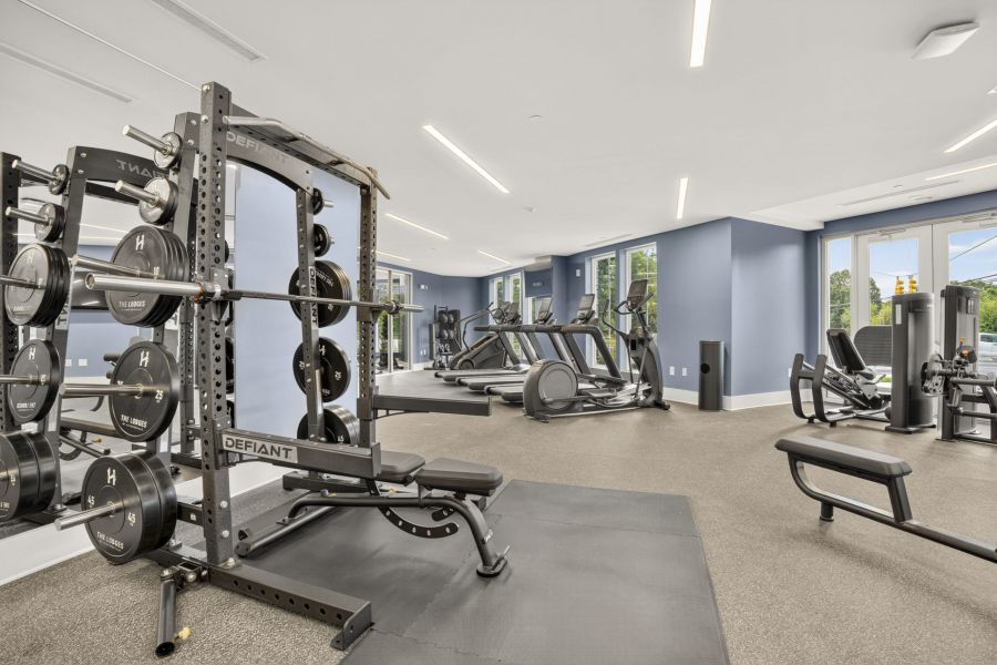 The Lodges of Huntersville A row of various dumbbells neatly arranged on a rack in a gym setting.