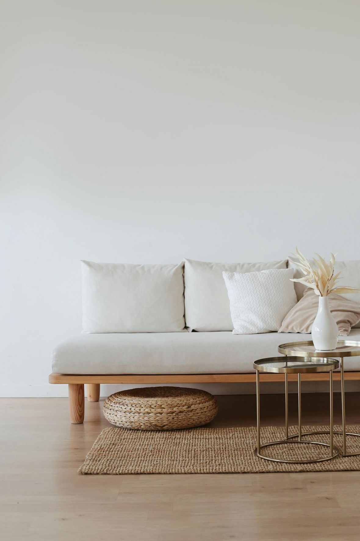 The Lodge of Huntersville A white couch positioned against a plain white wall in a minimalist room setting.